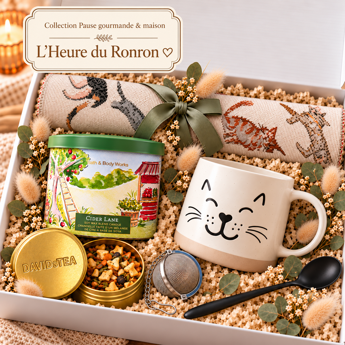 Coffret cadeau L’Heure du Ronron ouvert, avec napperon chats roulé, tasse chat crème, chandelle Cider Lane, thé DAVIDsTEA, infuseur et cuillère noire.